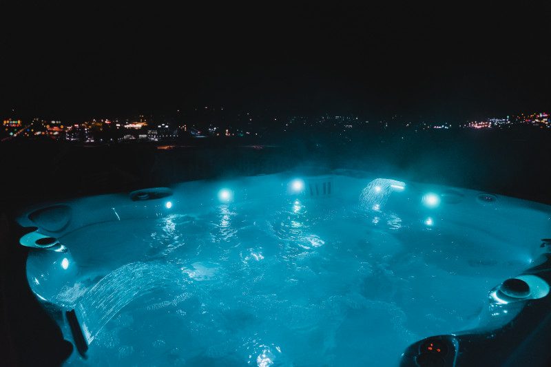 Caldera hot tub glowing on a patio after dark
