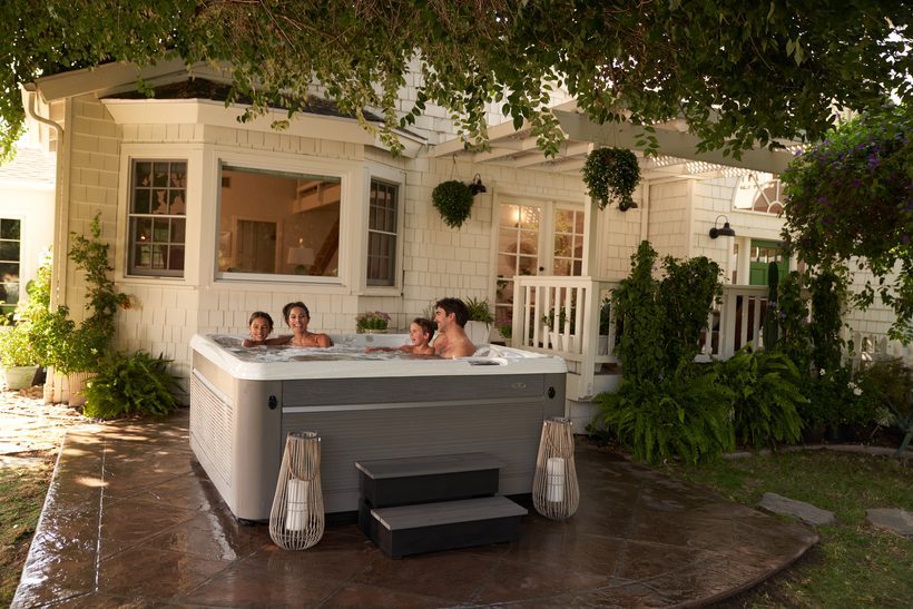 Caldera hot tub on a backyard patio at golden hour