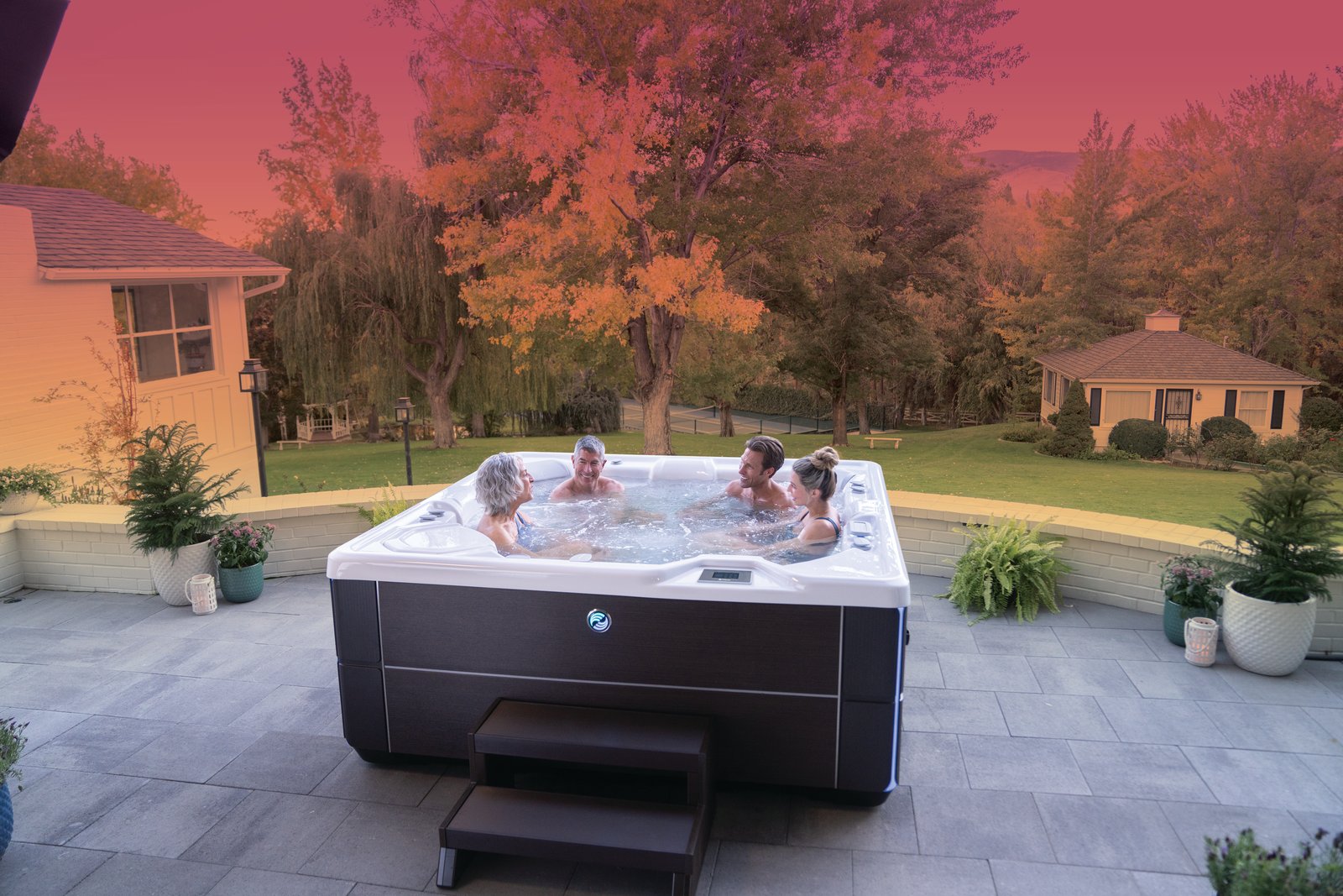 Family enjoying a Hot Spring Highlife Vanguard hot tub in a backyard