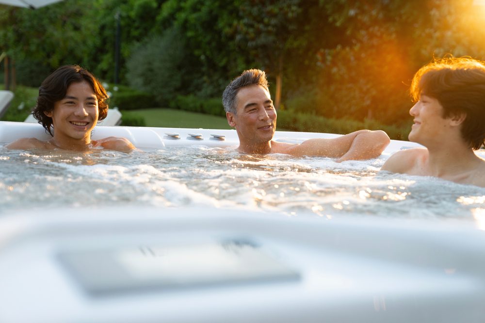 A family relaxing in a Hot Spring hot tub at sunset