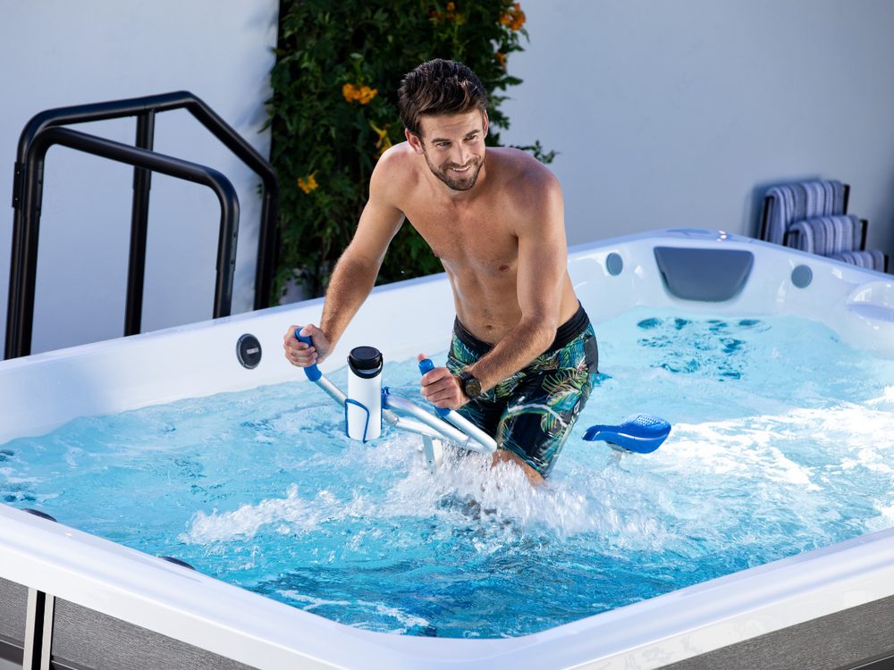 A man working out on an aqua bike in an Endless Pools swim spa